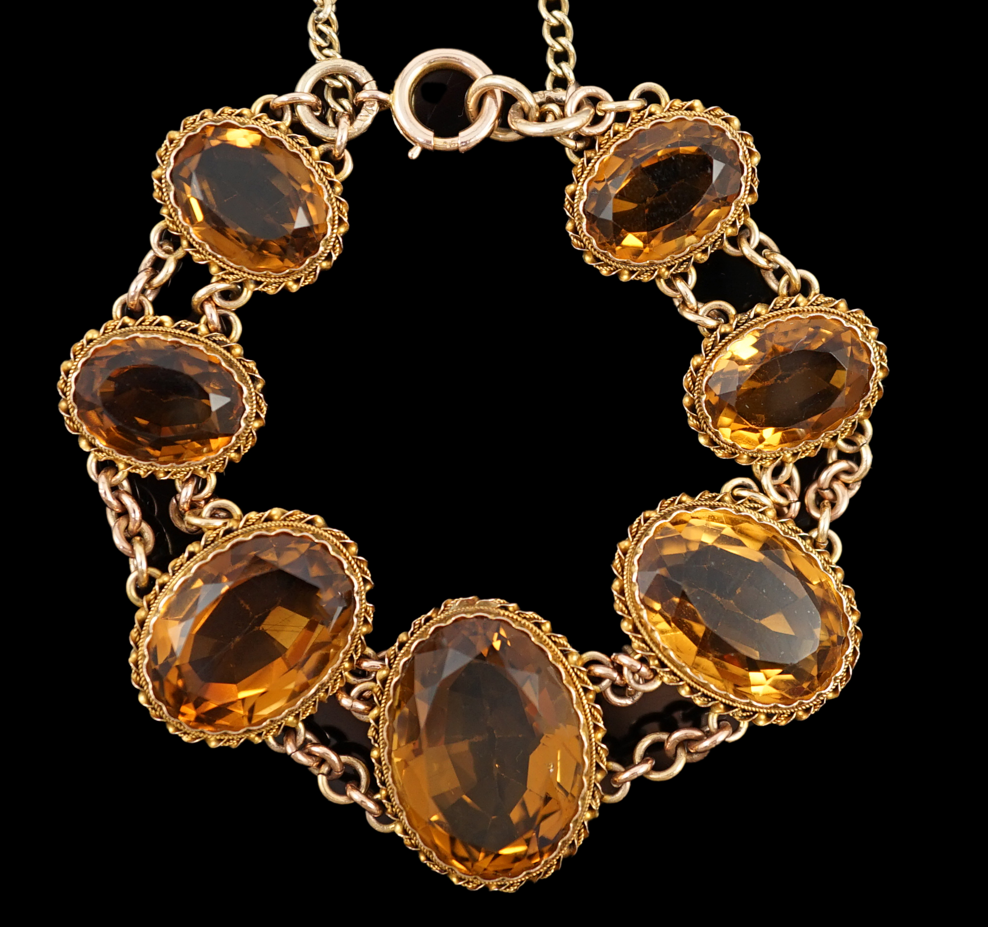 An early 20th century 9ct gold and graduated seven stone oval cut citrine set bracelet